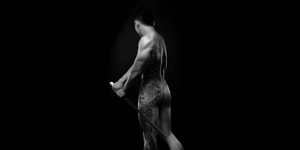 Rear view of a muscular man with detailed tattoos, symbolizing strength and the revitalizing effect of sports massages for men at Core Benefits Toowoomba.