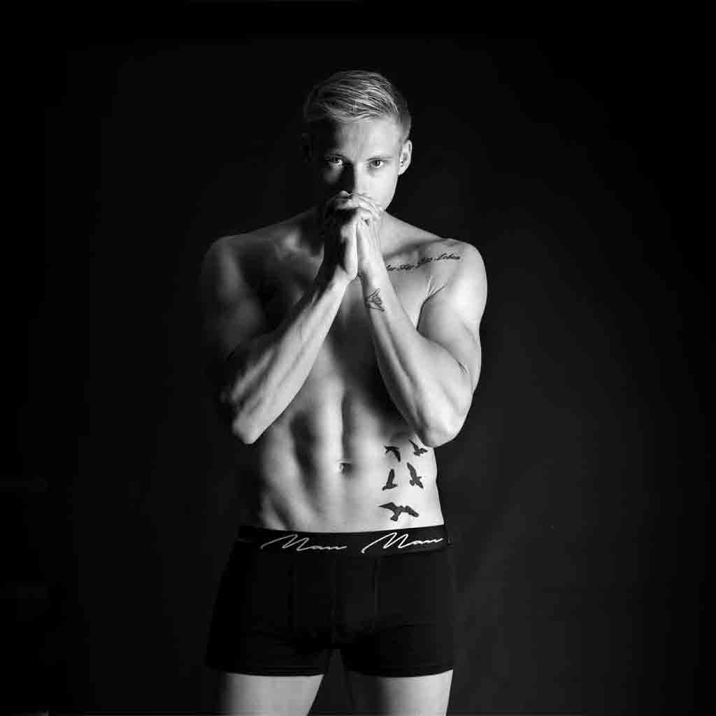 A serene black and white portrait of a contemplative man with his hands together, suggesting a moment of peace often associated with the results of men's skin treatments like RF Skin Tightening and laser Vascular Vein Removal. Core Benefits Toowoomba provides such services, including IPL Acne Treatments, laser Pigmentation Removal, Exfoliation Massage, Spray Tanning, and men's massage.