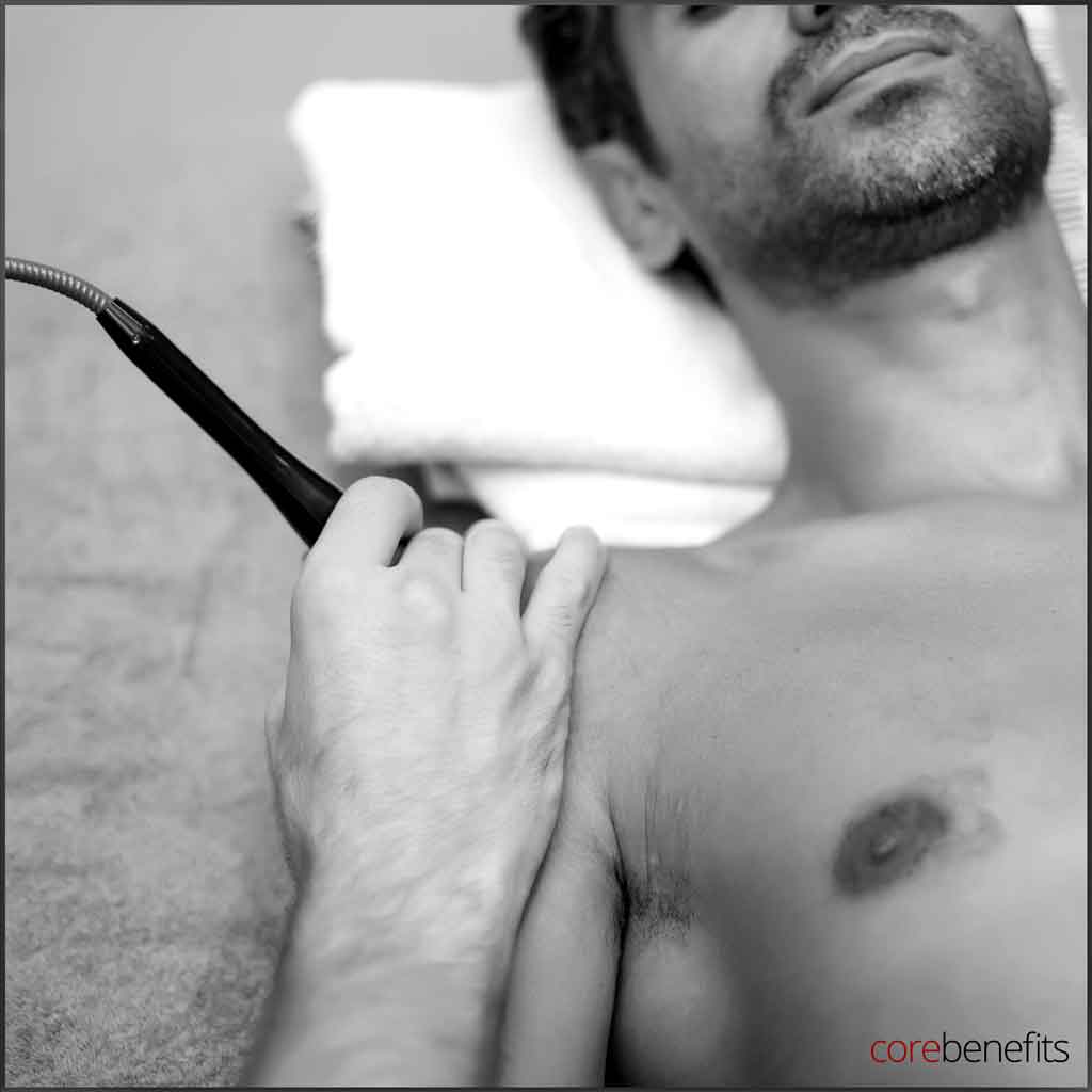 Black and white image of a man receiving ultrasonic cavitation therapy at Core Benefits Toowoomba, a modern technique in men's wellness for muscle pain relief, arthritis and ED treatments. Experience 'Bare to Bold: Effortless Confidence' with cutting-edge care.