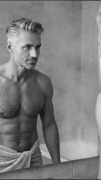 Man with grey hair styling and checking tone after using DEPOT No.104 Silver Shampoo to reduce yellow and brassy tones